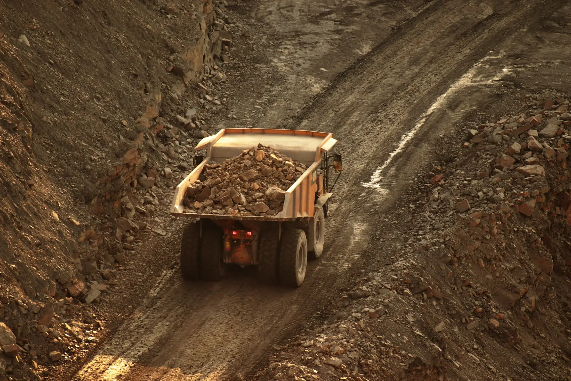 Tipper truck hauling a load of rock up a quarry haul road, the kind of plant-heavy contractor business a director might restart after a liquidation